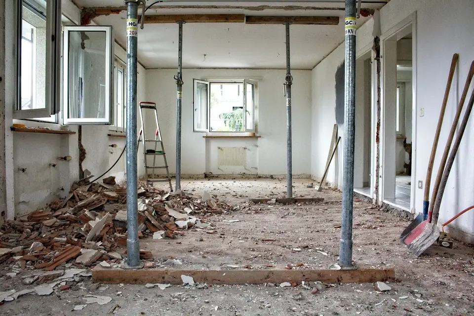 Gutted kitchen with plastic dust containment walls and floor protection during interior demolition — Worcester, MA