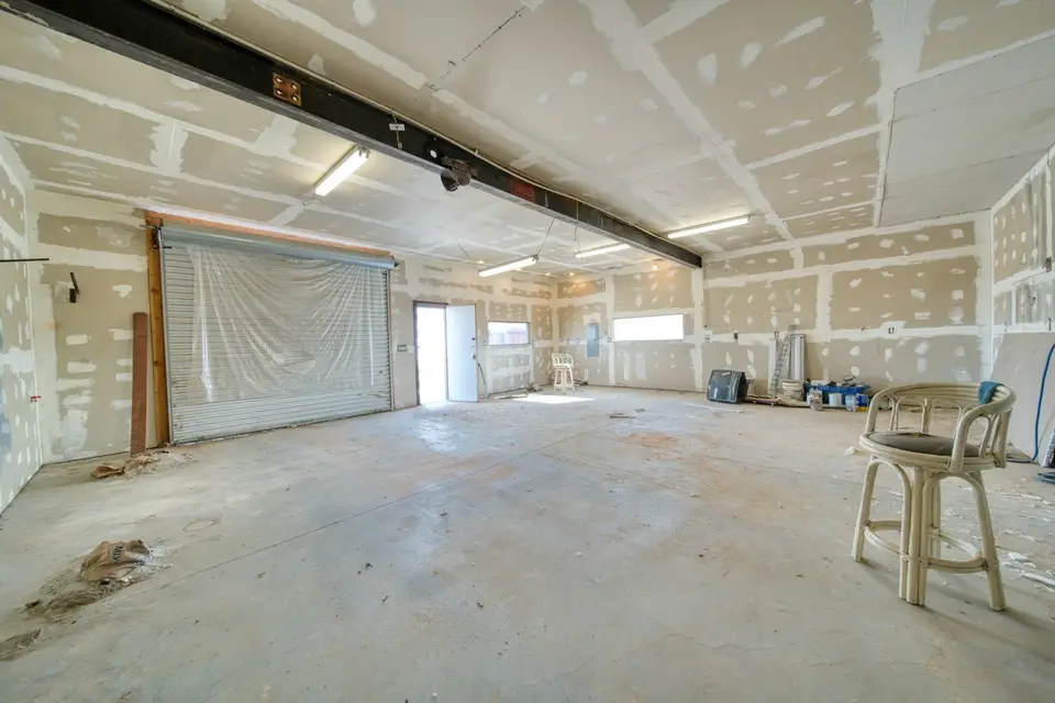 Repaired drywall patch on a living room wall, feathered and ready for paint