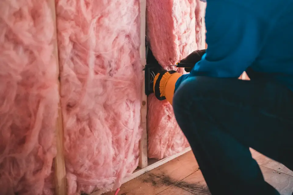 Blown-in cellulose insulation covering attic floor joists with ventilation baffles at the eaves